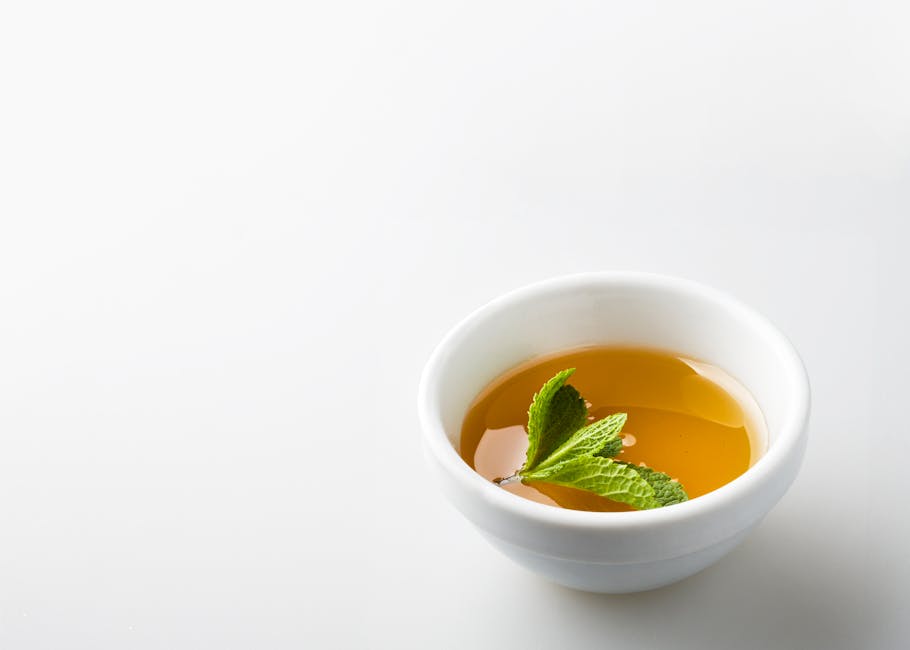 A close-up shot of herbal tea with mint leaves in a white bowl, perfect for food photography.
