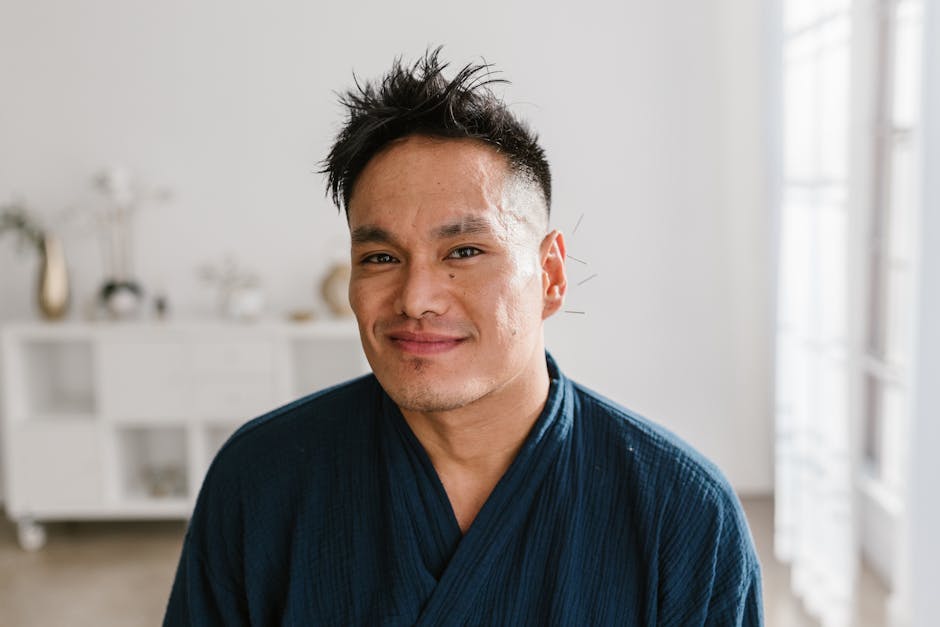 Portrait of a smiling man receiving acupuncture treatment indoors, promoting wellness and alternative medicine.