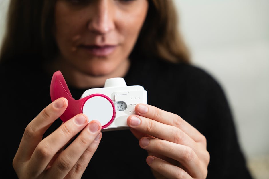 Close-up of a woman holding a medical inhaler device for respiratory conditions.