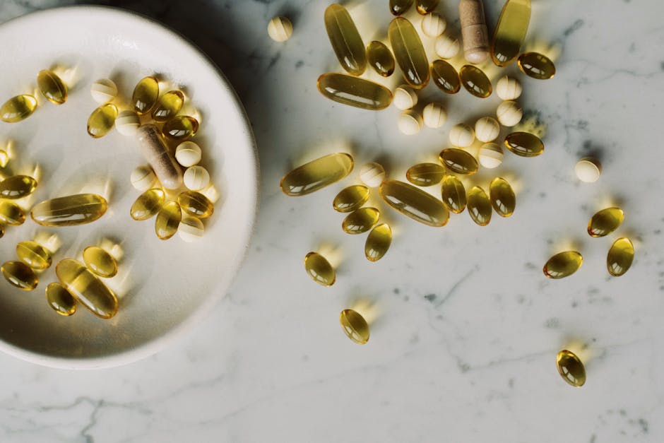 Top view of gelatin coated multivitamin pills placed on marble tabletop near plate with various drugs in studio at day time