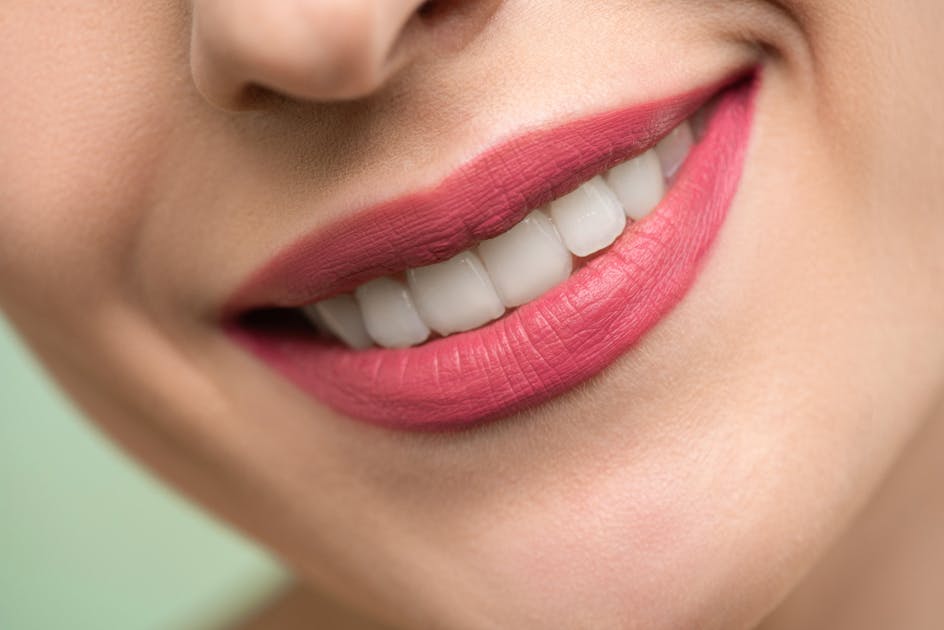 Woman with healthy smile showing results of good gum care