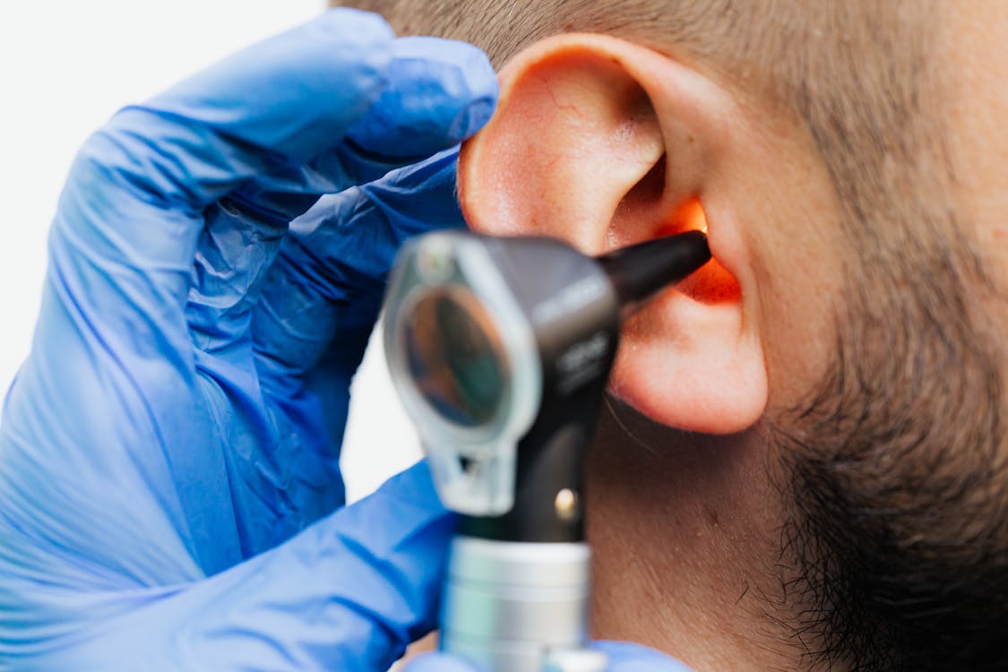 Doctor examining patient ear - can high blood pressure cause ear ringing