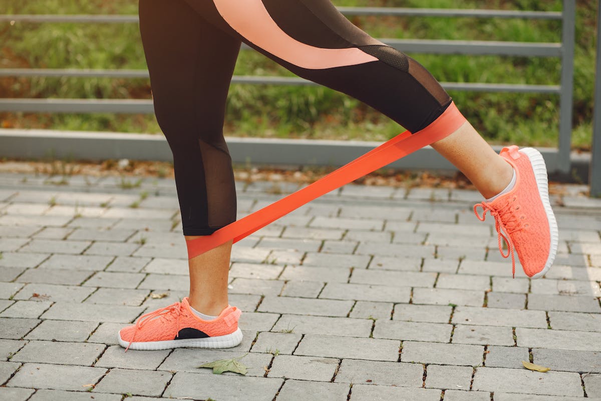 Person doing a resistance-band leg exercise outdoors to improve circulation and reduce swelling