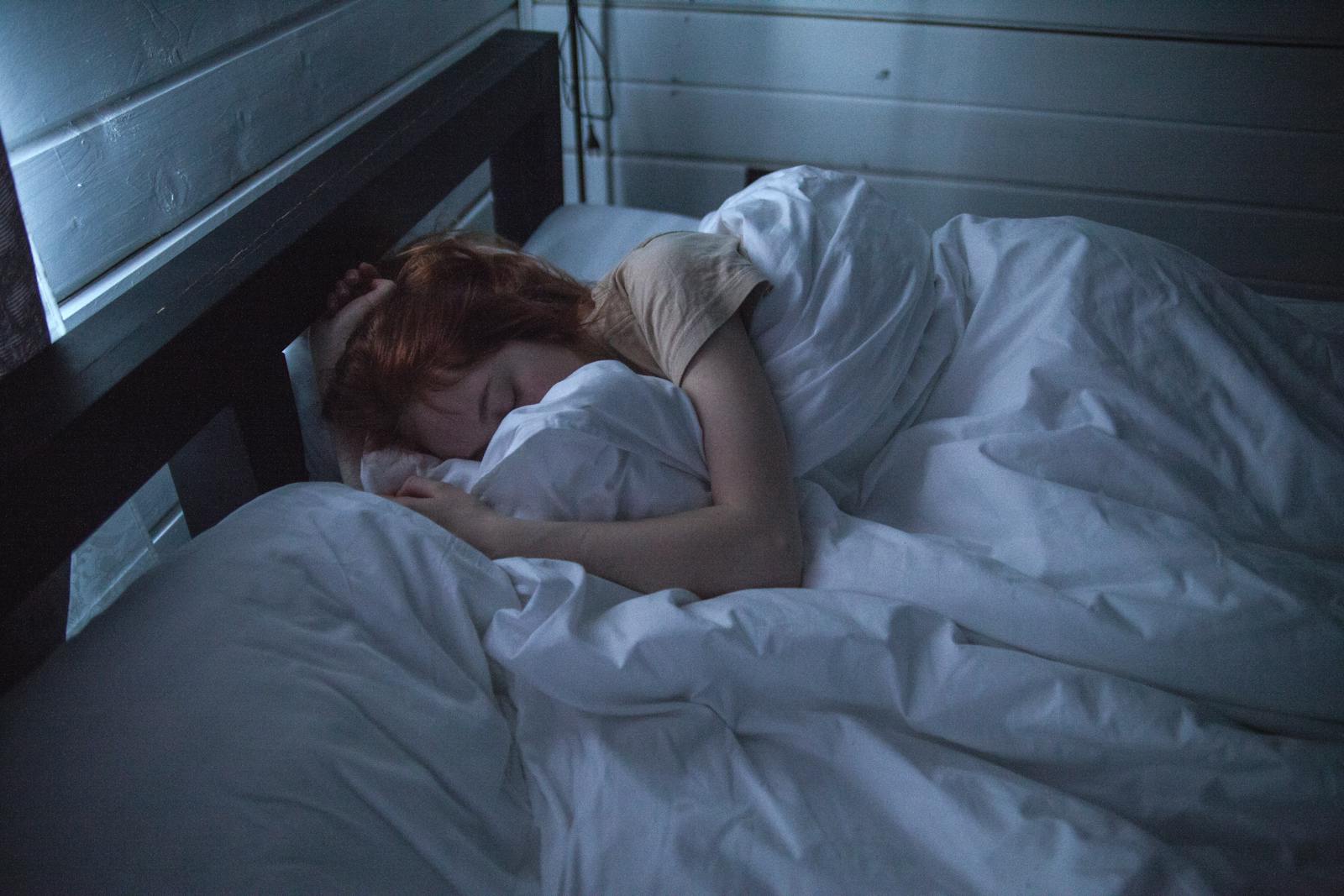 Woman awake in bed at night looking worried during a 3AM wake-up
